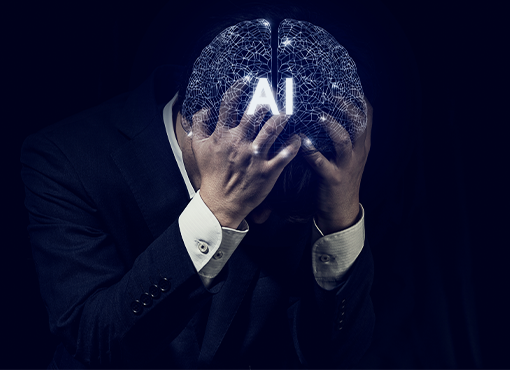 A man in a dark suit and white shirt holds his head in his hands, with a glowing digital brain graphic featuring the text 'AI' over his face, set against a very dark background. Portrays frustations with using AI.